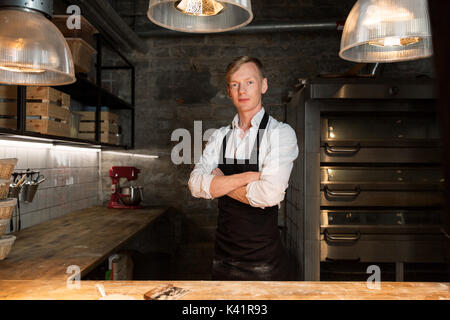 Chef o baker nel grembiule in cucina da forno Foto Stock