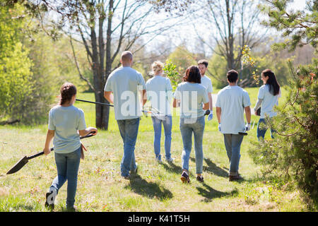 Felice volontari con piantine e attrezzi da giardino Foto Stock