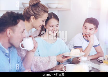 Famiglia positivo gustando la prima colazione insieme Foto Stock