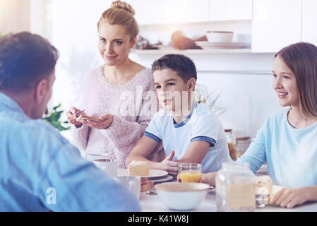 Famiglia adorabile ascolto di padre di parlare durante il pasto di famiglia Foto Stock