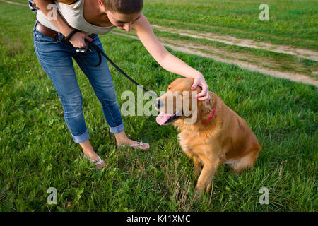 Elegante giovane donna e la sua famiglia cane golden retriever. Foto Stock