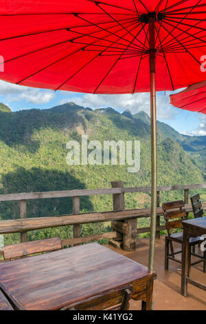 Bella outdoor cafe con tradizionale tailandese rossa ombrelloni nel nord della Thailandia. Foto Stock