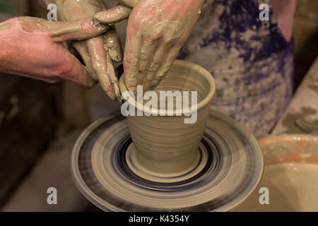 In ceramica. la maestra insegna il lavoro degli studenti sul tornio del vasaio. Foto Stock