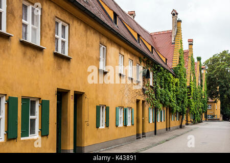 Vista sulla strada del quartiere di Fuggerei insediamento, il più antico del mondo sede sociale complesso è ancora in uso, Augsburg, Baviera, Germania Foto Stock