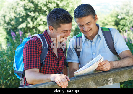 Padre Con figlio adulto guardando la mappa sulla passeggiata in campagna insieme Foto Stock