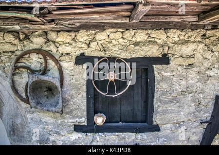 Campagna, east serbia - chiuso le persiane alle finestre e parti di vecchie apparecchiature sul muro di pietra di un ex cantina Foto Stock