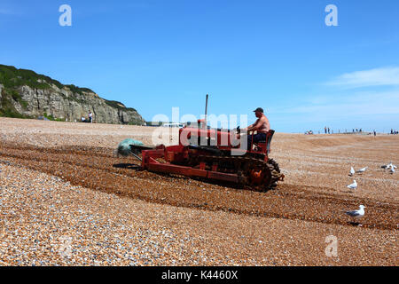 Guida del pescatore di bulldozer utilizzato per spingere barche da pesca fino spiaggia ghiaiosa, Hastings, East Sussex, Inghilterra Foto Stock