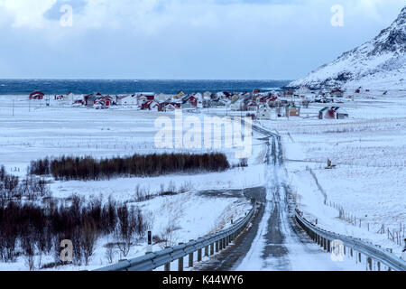 La strada ghiacciata al tipico villaggio di pescatori circondato da neve e ghiaccio Unstad mare Isole Lofoten in Norvegia Europa Foto Stock