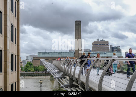 London, Regno Unito - 3 Agosto 2017: Guardando verso la Tate Modern di fronte il Millennium Bridge. Mostra la gente camminare sopra il ponte. Foto Stock