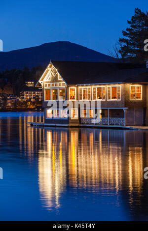 Stati Uniti d'America, New York, Montagne Adirondack, Lake Placid, Lake Placid Club Boathouse, ristorante sul lago a specchio, crepuscolo Foto Stock