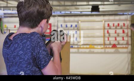 Ragazzo adolescente germogli in un trattino dalla macchina lifestyle pistola. Carabine pistola. boy gun Foto Stock