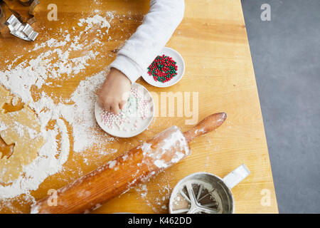 Ragazza la cottura biscotti di Natale, dettaglio mano, perle di zucchero, Foto Stock