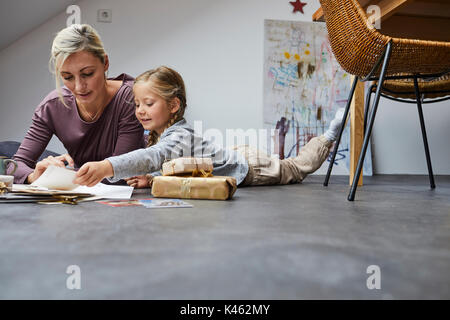 Madre e figlia scrivere cartoline di Natale Foto Stock