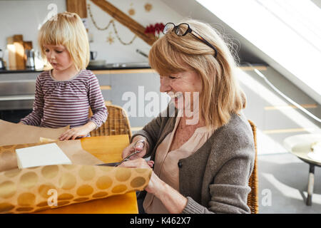 Nonna e nipote impacchettare i regali di Natale Foto Stock