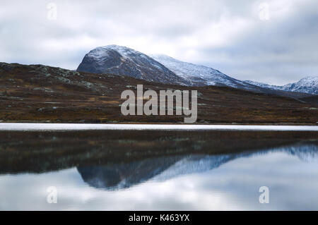 Montagne dalle vette innevate riflettente nel lago Bygdin. Da Jotunheimen Norvegia Foto Stock