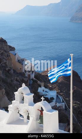 Icone di Santorini in Oia, Grecia compresa la bandiera greca che si affaccia sul mare Foto Stock