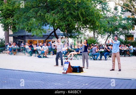 Tre persone che praticano Falun Dafa o Falun Gong, un sistema buddista di esercizio per la mente e per il corpo, a Madison Square Park di New York City Foto Stock