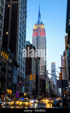 Empire State Building di notte che mostra i colori della bandiera americana, rosso, bianco e blu Foto Stock