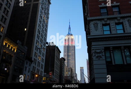 Empire State Building di notte che mostra i colori della bandiera americana, rosso, bianco e blu Foto Stock