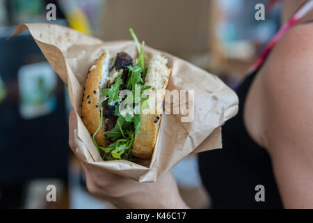 Donna che mantiene succosa burger nelle sue mani. Foto Stock