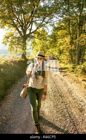 Alla scoperta di magiche vedute della Toscana. A piena lunghezza ritratto di donna attiva escursionista in hat con sacchetto sulla Toscana escursione Foto Stock