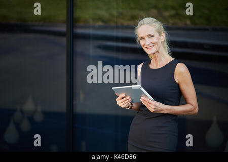 Ritratto di Coppia sorridente imprenditrice tenendo compressa. Foto Stock