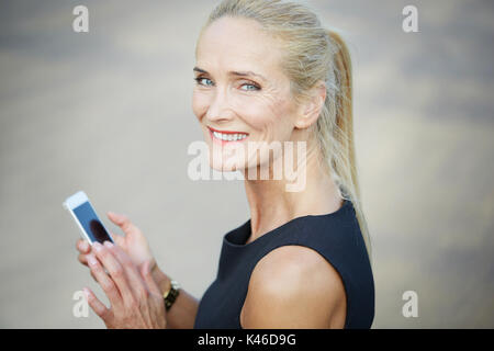 Close up ritratto di sorridere imprenditrice utilizzando il telefono cellulare. Foto Stock