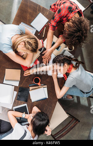 Vista aerea del stanco dei giovani studenti di dormire sulla tabella con i notebook e i dispositivi digitali Foto Stock