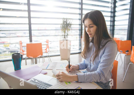 Ritratto di giovane donna oberato di lavoro crea un nuovo progetto per il lavoro. Foto Stock