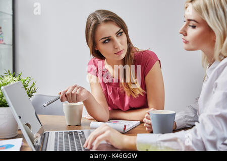 Ritratto di due imprenditrici in home office di lavoro sul computer portatile. Foto Stock