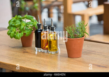 Aceto balsamico e bottiglie di olio e condimenti sul tavolo in un cafe' all'aperto Foto Stock