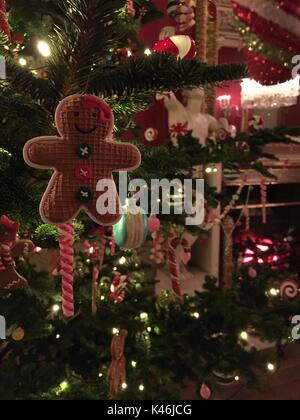 Gingerbread Man decorazione pende da una tradizionale struttura ad albero di natale Foto Stock