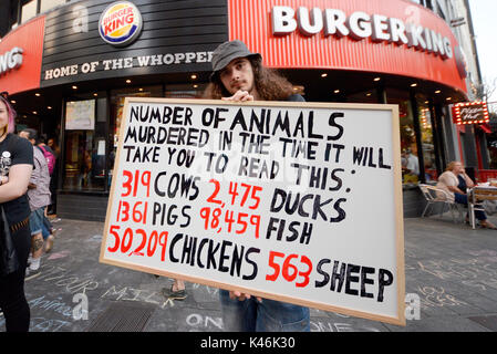 Attivisti per i diritti degli animali che protestavano davanti al Burger King nel quadrato di Leicester, Londra. Shock tattica sulla targhetta Foto Stock