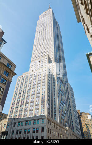 Empire State Building a basso angolo di visione, cielo blu chiaro in una mattina di sole in New York Foto Stock