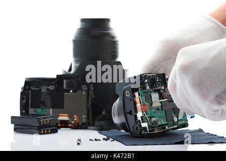 Mani con screwdiver aperta moderna fotocamera foto closeup isolati su sfondo bianco Foto Stock