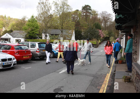 I turisti a piedi lungo College Street nel centro del villaggio di Grasmere nel Distretto del Lago, Cumbria Foto Stock