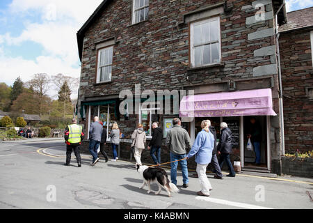 I turisti a piedi nel centro del villaggio di Grasmere nel Distretto del Lago, Cumbria Foto Stock