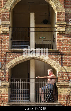 Oxford, Regno Unito. Un uomo a prendere il sole nella Chiesa di Cristo di vecchi edifici (1846) off l'Osney Lane Foto Stock