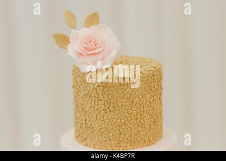 Coprimaterasso per torta di nozze a glassa di colore rosa pastello e oro Foto Stock