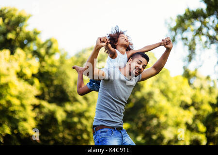 Ritratto di giovane padre portando la sua figlia sul suo retro Foto Stock