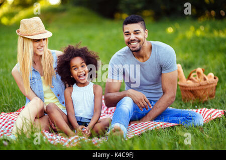 Immagine della coppia adorabile con la loro figlia avente picnic Foto Stock