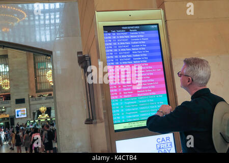 Uomo Senior controllo treno Partenze pensione in Grand Central Terminal, NYC, STATI UNITI D'AMERICA Foto Stock