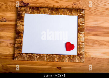 Layout con vuoto photo frame con piccolo cuore rosso. Libera spazio di copia Foto Stock