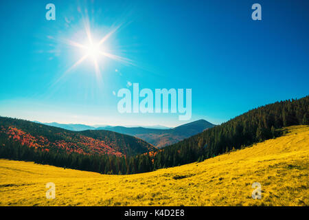 Montagne di colore arancione e il sole nel cielo blu Foto Stock