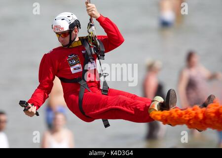 Un membro della Red Devils Parachute Team divertirsi sul Bournemouth filo Zip Foto Stock