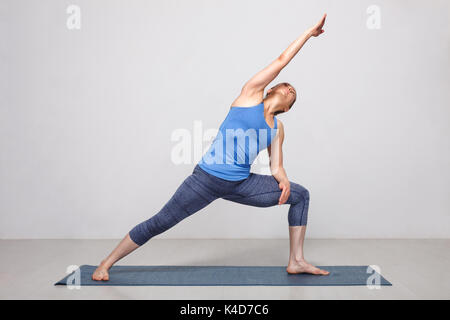 Donna facendo Ashtanga Vinyasa yoga asana Utthita parsvakonasana Foto Stock