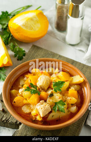 La Turchia stufato con zucca, spezie e verdure in una ciotola su una pietra dello sfondo. Foto Stock