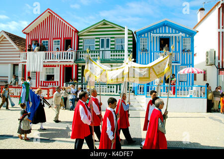 Processione religiosa durante la tradizionale festa di Nossa Senhora da Saúde. Sullo sfondo le tradizionali case di legno di Costa Nova, Portog Foto Stock