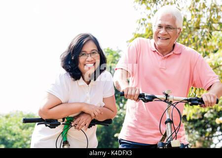 Ritratto di active coppia senior in piedi sulle biciclette Foto Stock