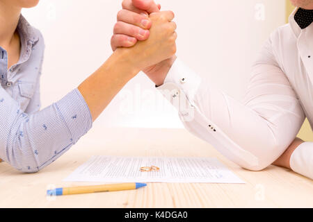 Primo piano di un giovane uomo di una giovane donna di firmare un accordo prematrimoniali Foto Stock